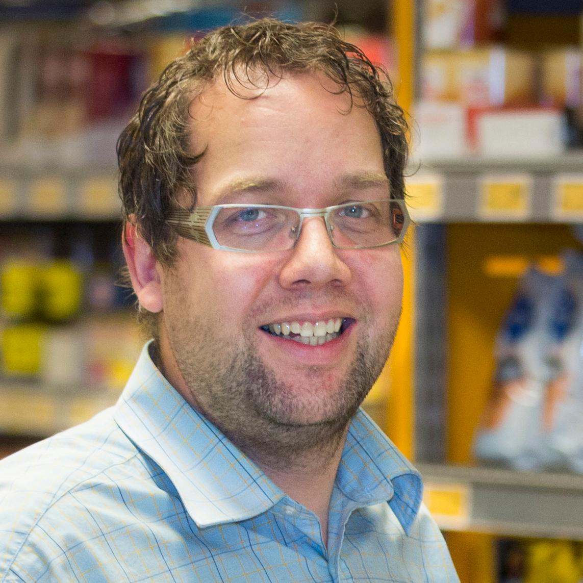 en mann i butikkuniform i en dagligvare