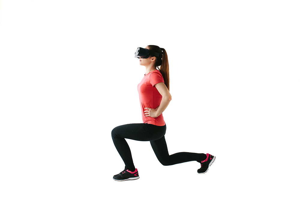 Dame med VR-briller på gjennomfører fysiske øvelser.