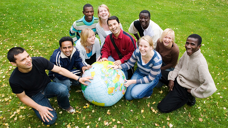 Students gathered around a globe