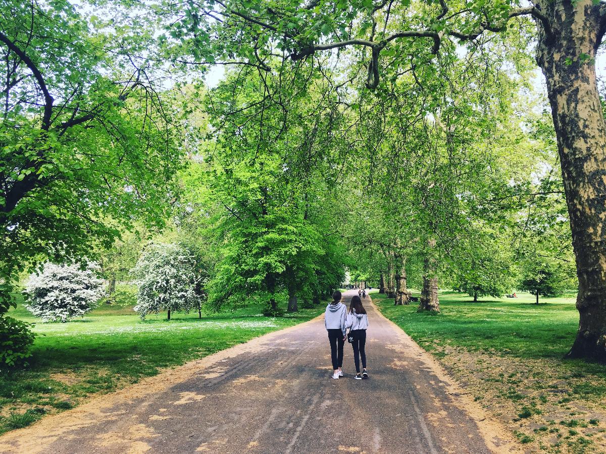 to jenter som går gjennom en park