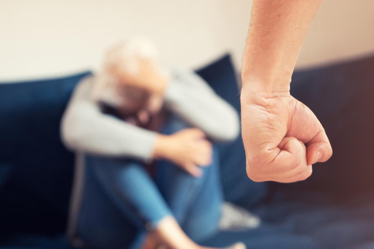 Knyttet håndneve og kvinne i sofa