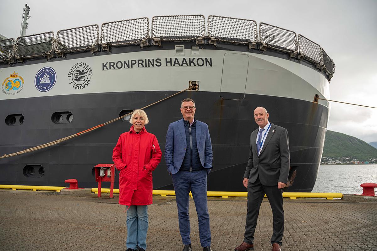 En kvinne og to menn foran baugen på forskningsskipet Kronprins Haakon ved kai i Tromsø