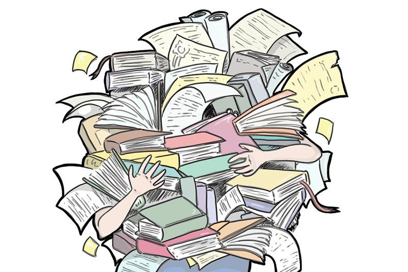 Person holding a large pile of books and papers so that only the legs and feet are visible.
