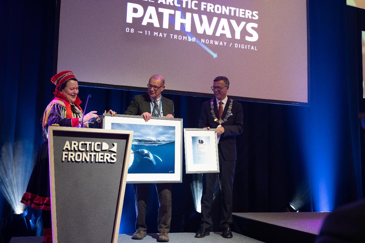  Professor John E. Walsh received the Mohn Prize 2022 from Sami Parliament President Silje Karine Muotka during the Arctic Frontiers conference on Monday afternoon. To the right is the rector of UiT, Dag Rune Olsen.