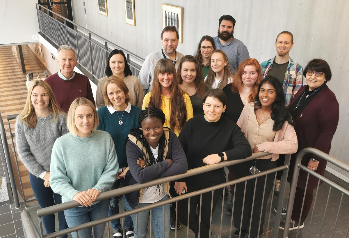 Ei gruppe menneske poserer samla p&aring; ei trappeavsats