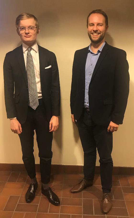 Stian and Marius standing next to each other, wearing suits, smiling.