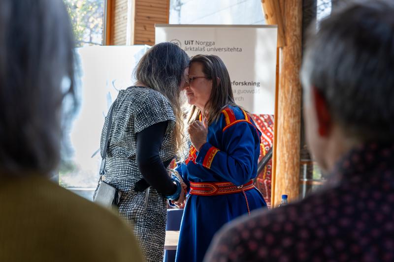 To kvinner står panne mot panne. Biletet er tatt frå mellom to tilskodarar.