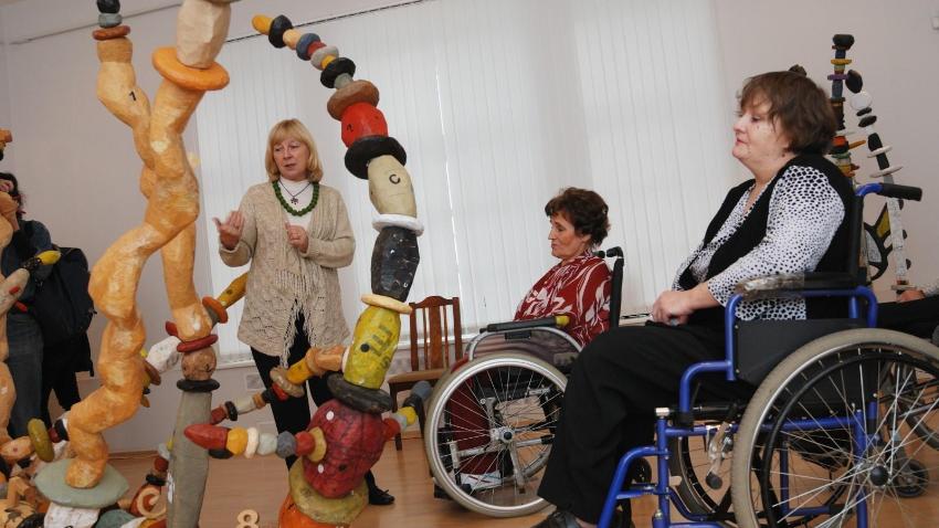 Persons in wheel-chairs attending art tour