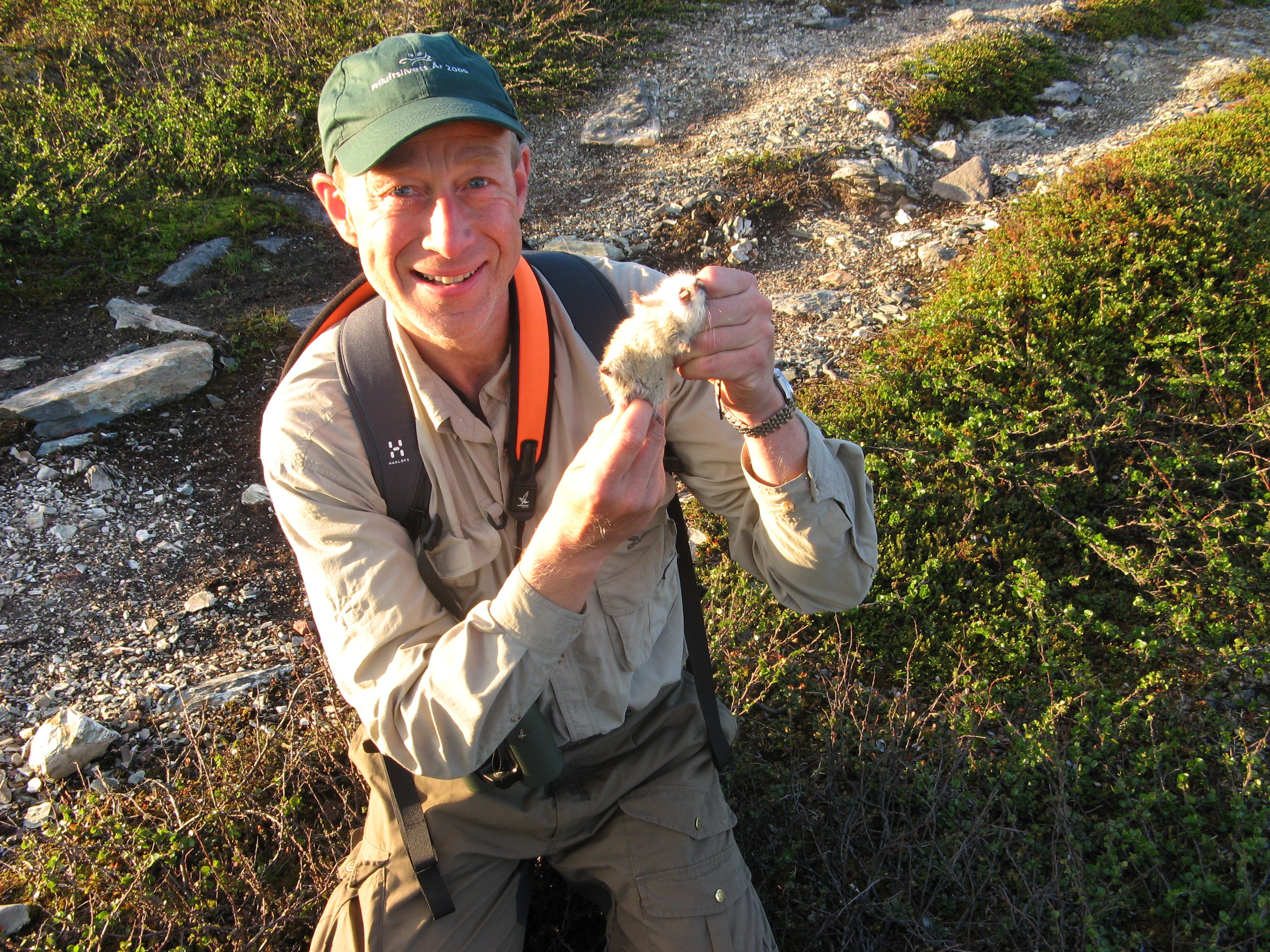 a man holding a lemmings out in the field