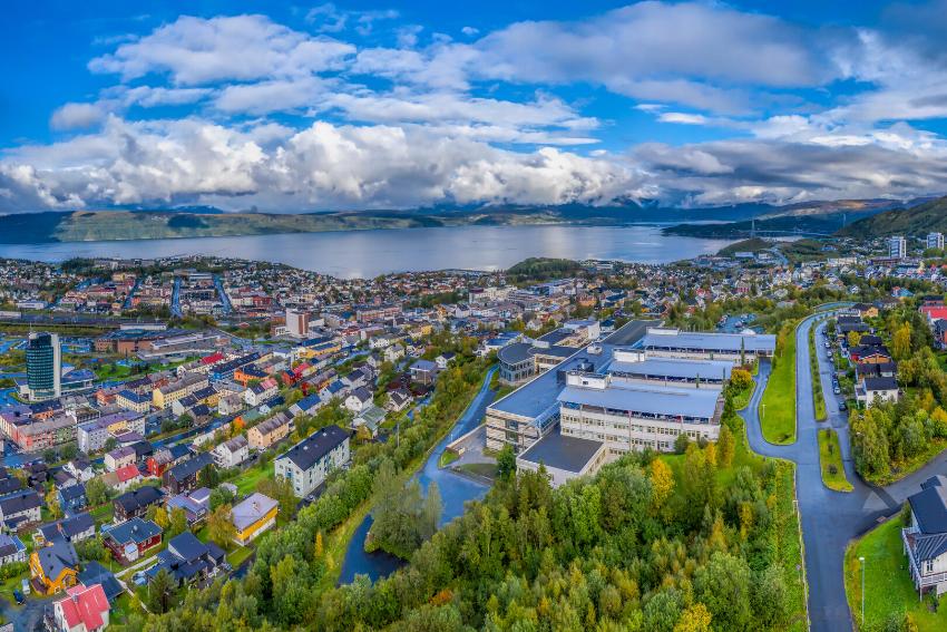 University buildings with mountains and fjords in the background.