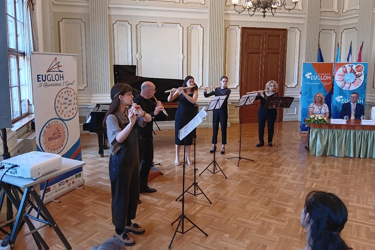 Personar som spelar musikk i eit stort rom.