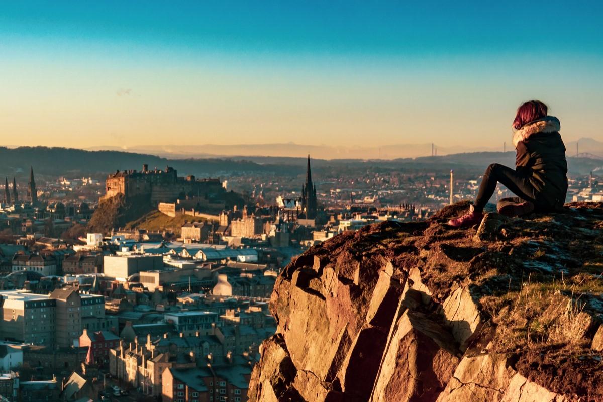 A person sitting on a hill overlooking a town 