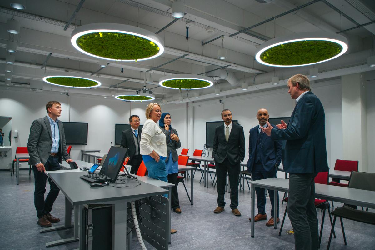 People in a room with large, circular lamps hanging over them