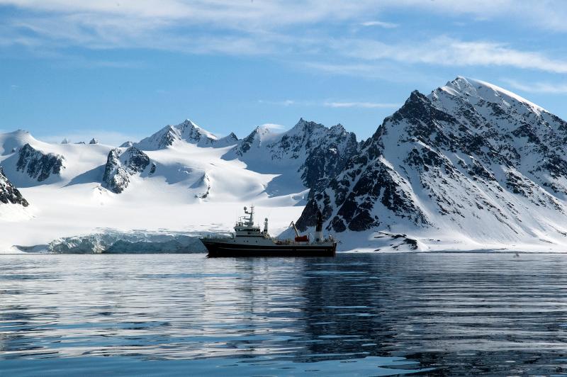 Boat among snow cowered mountains.