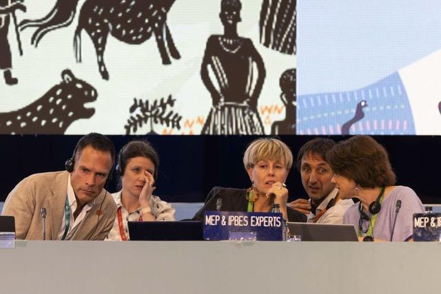 Five people sitting at a table, leading a plenary.