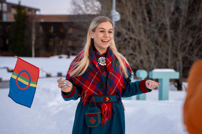 Kvinne med samekofte på campus i vinterdrakt