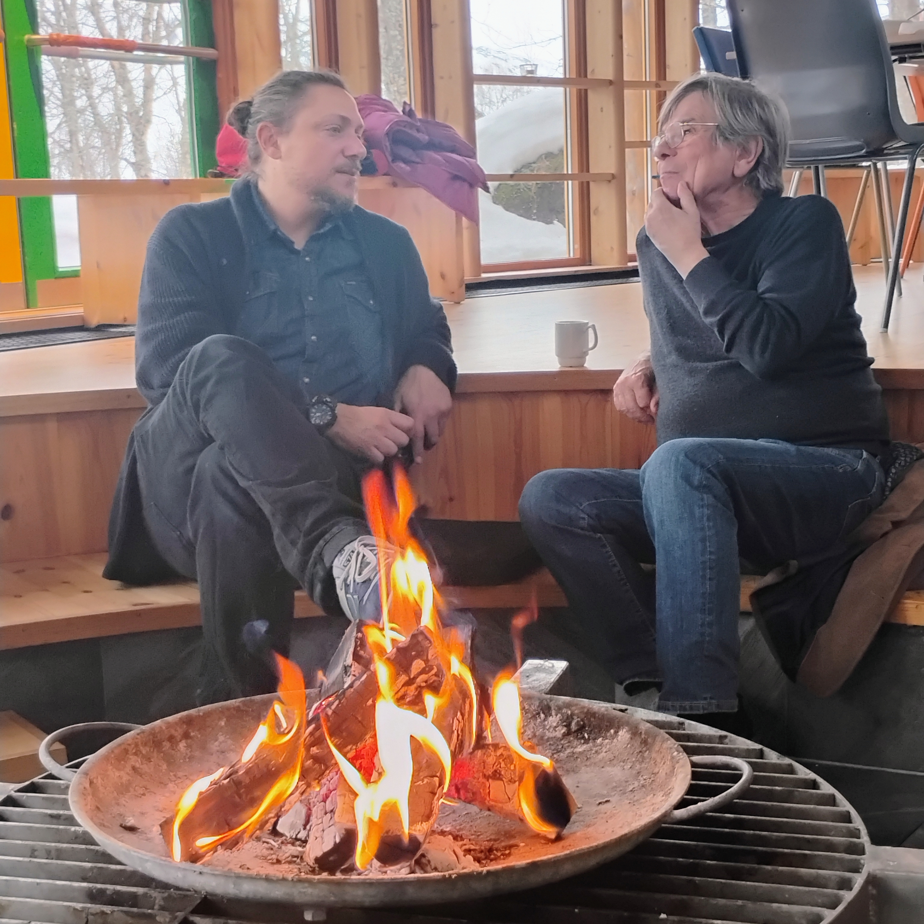 Nandor and Hans-Jörg sitting by the fireplace talking during lunch