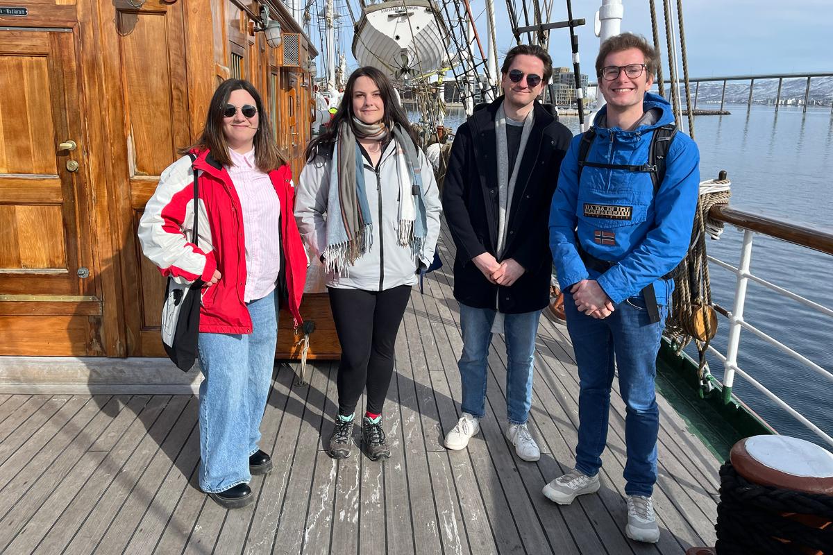 Fire unge mennesker st&aring;r ved siden av hverandre. 