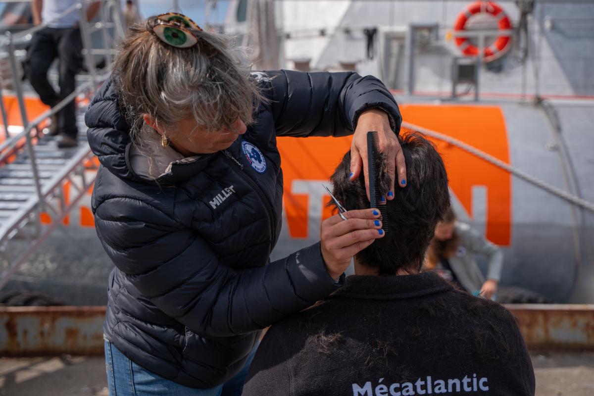 Mannskap_pa_Tara_Polar_Station_far_en_harklipp_UIT_28989_Foto_Jorn_Berger_Nyvoll.jpg En person klipper håret til en annen.