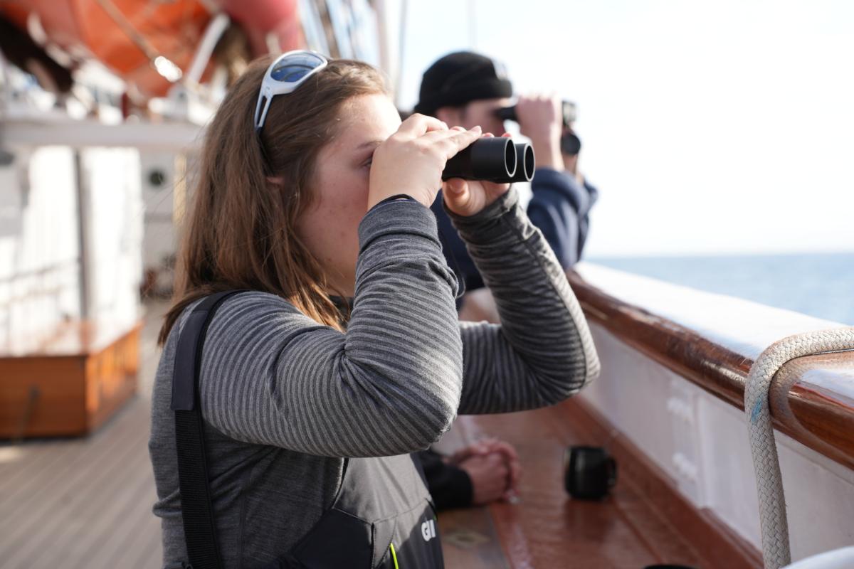 To personer ser i hver sin kikkert. 