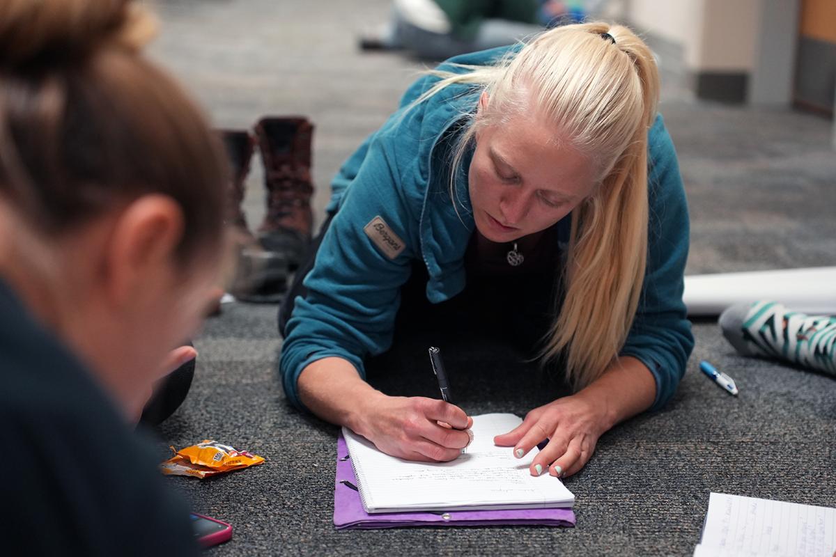 En ung kvinne skriver på et papir