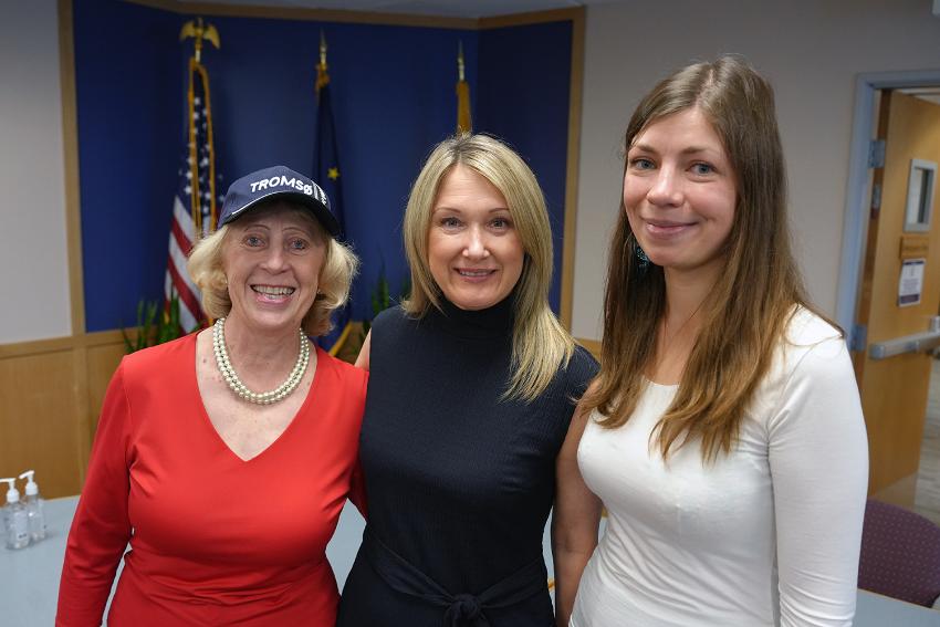 Three persons standing beside each other.