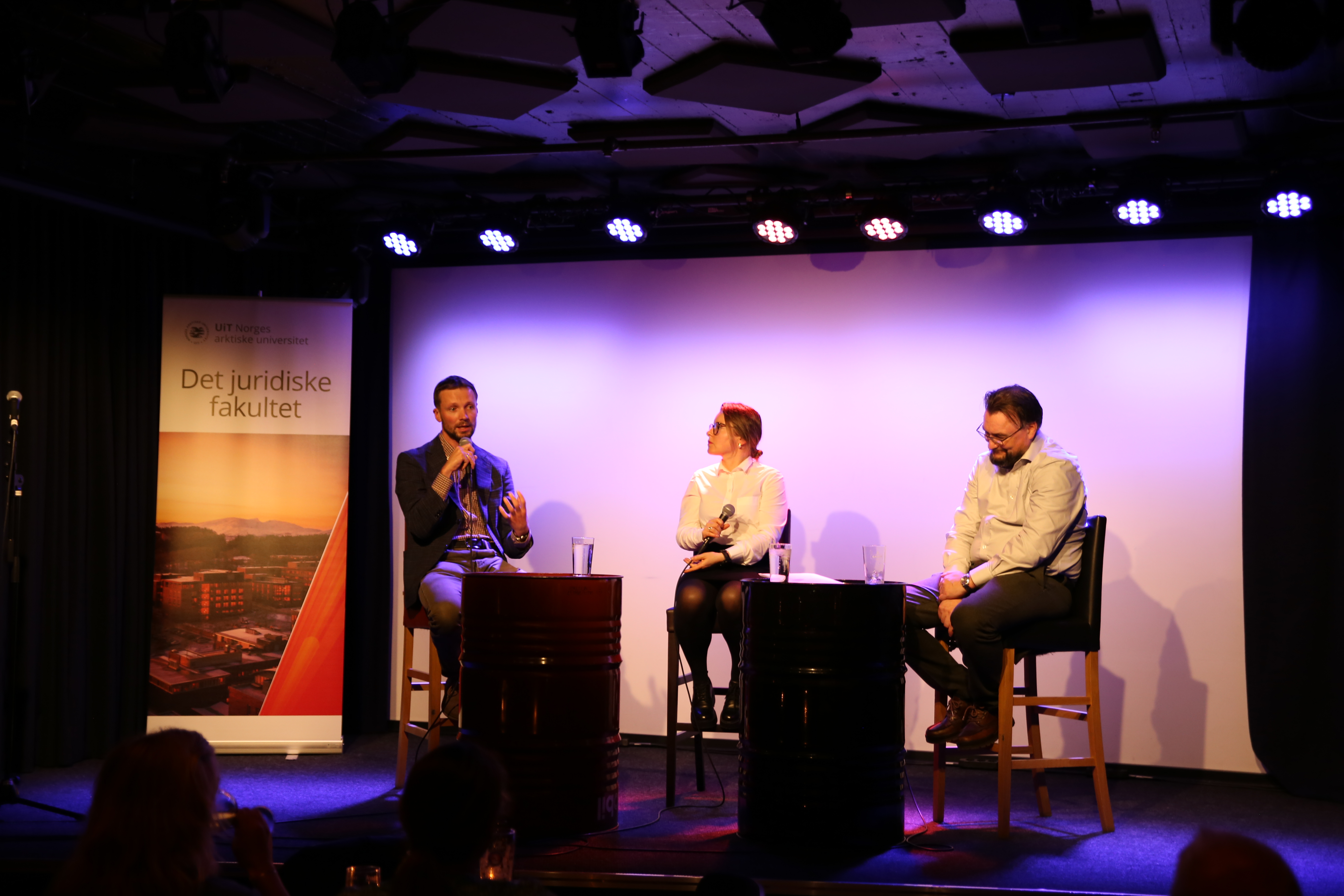 mann til venstre, kvinne i midten, og mann til høyre i samtale. 