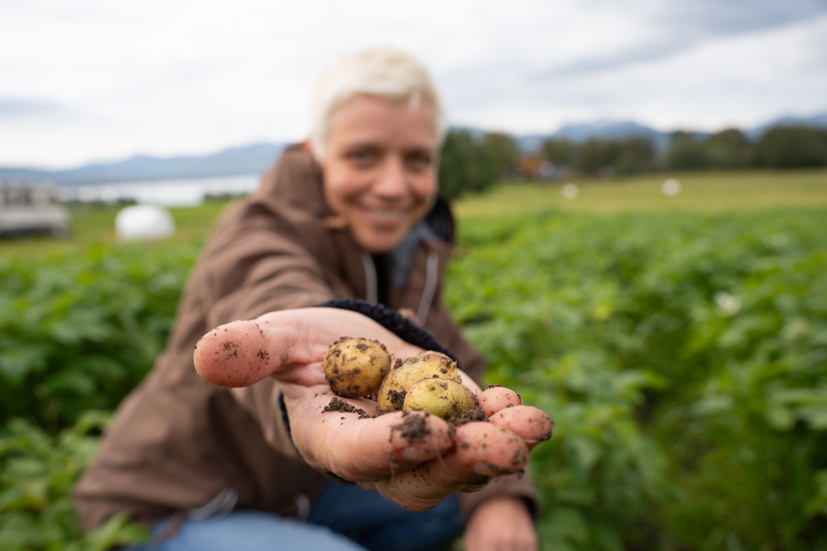 dame som holder poteter i en utstrakt h&aring;nd