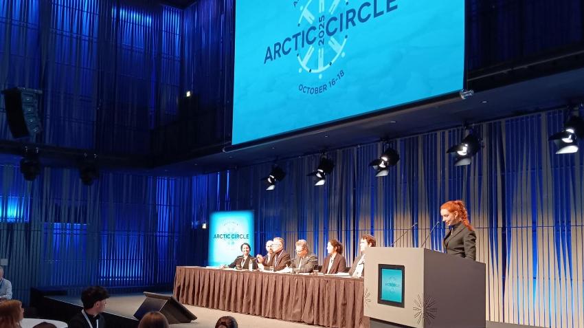 A debate panel with an audience below the stage
