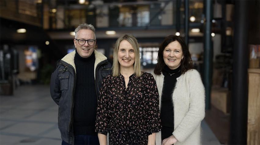 De tre artikkelforfatterne står i foajeen ved UiT i Harstad og ser inn i kamera