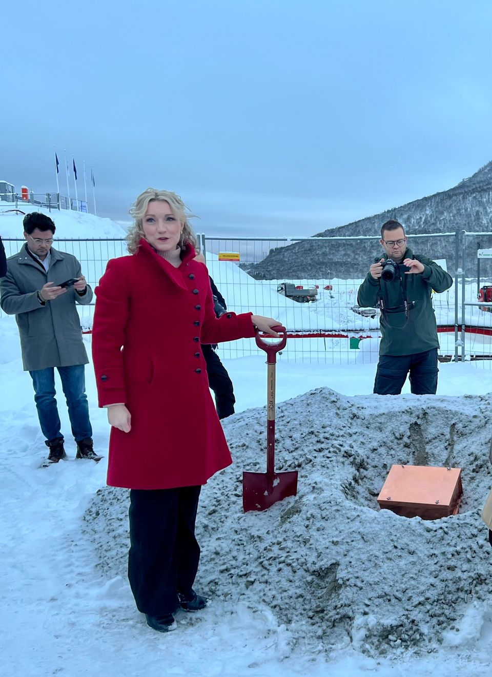 En kvinne som står holder en spade.