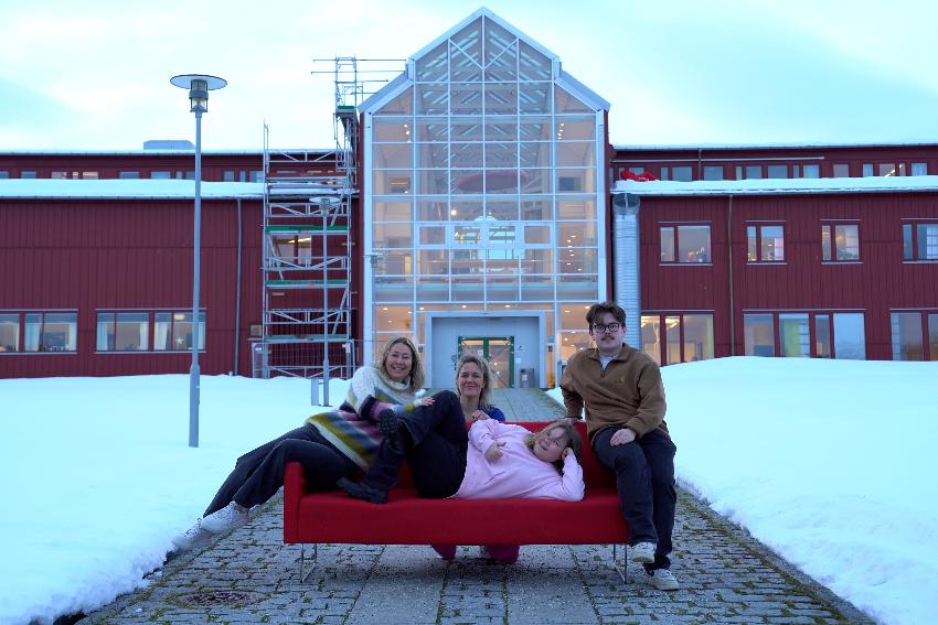 Fire personer sitter og ligger på en sofa.