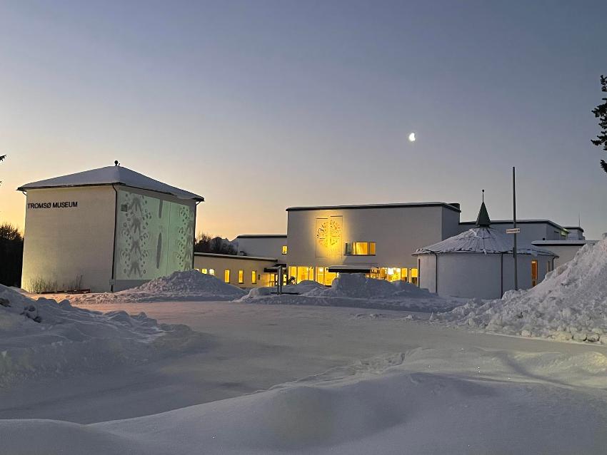 Unger som leker i snøen utenfor museet