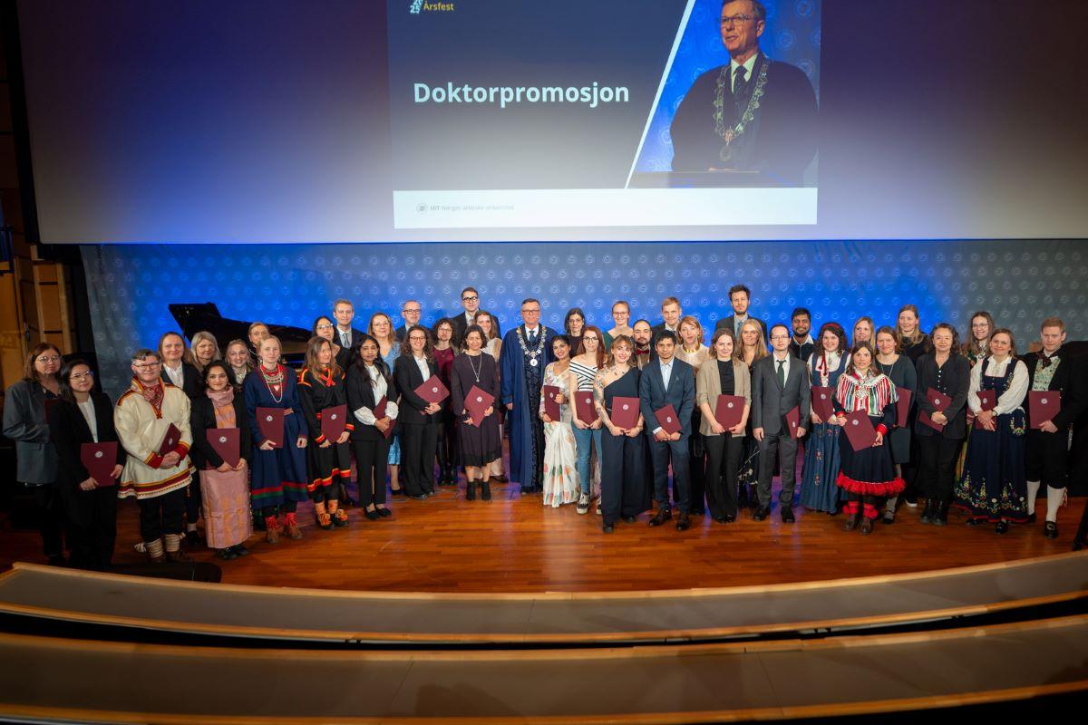 en gruppe pent kledde mennesker fremst i et auditorium