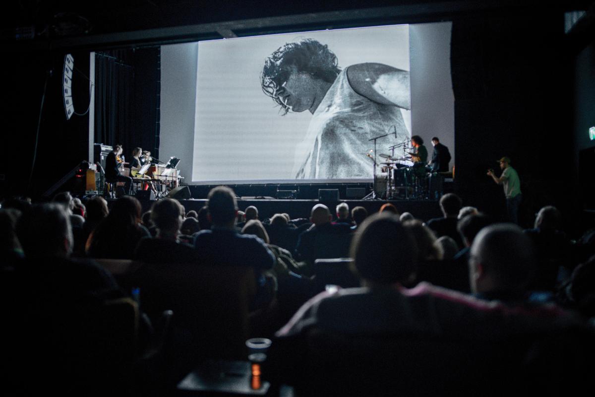Svart-hvitt film-konsert-visning med publikum. 