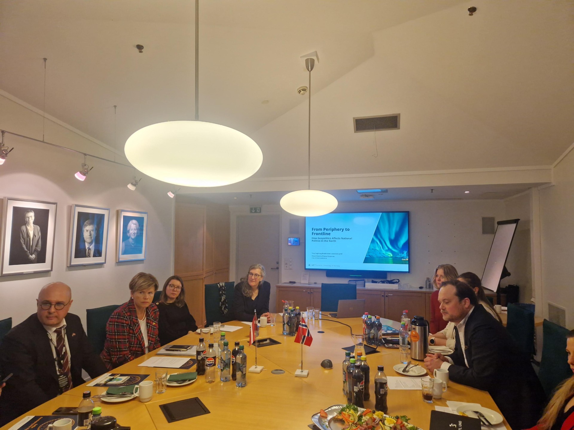 multiple people, sitting around a table, discussing