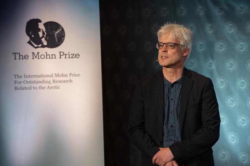 En mann snakker p&aring; en scene