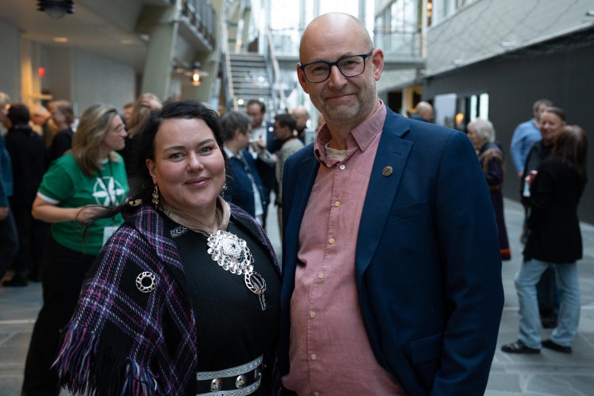 Dame og mann smiler til fotograf