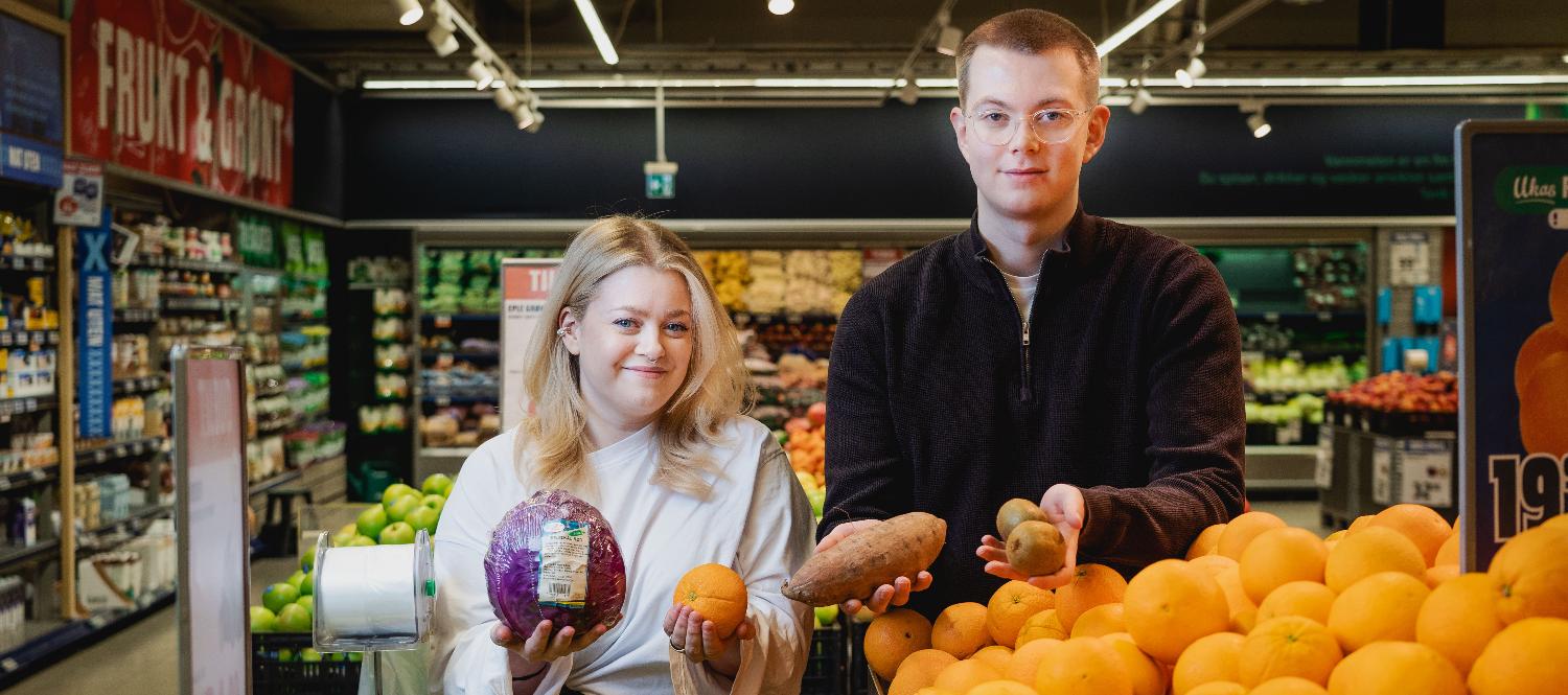 Ern&aelig;ringsstudenter holder opp ulike gr&oslash;nnsaker i et supermarked