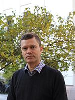 mann, kort h&aring;r, m&oslash;rtk h&aring;r, ser i kamera