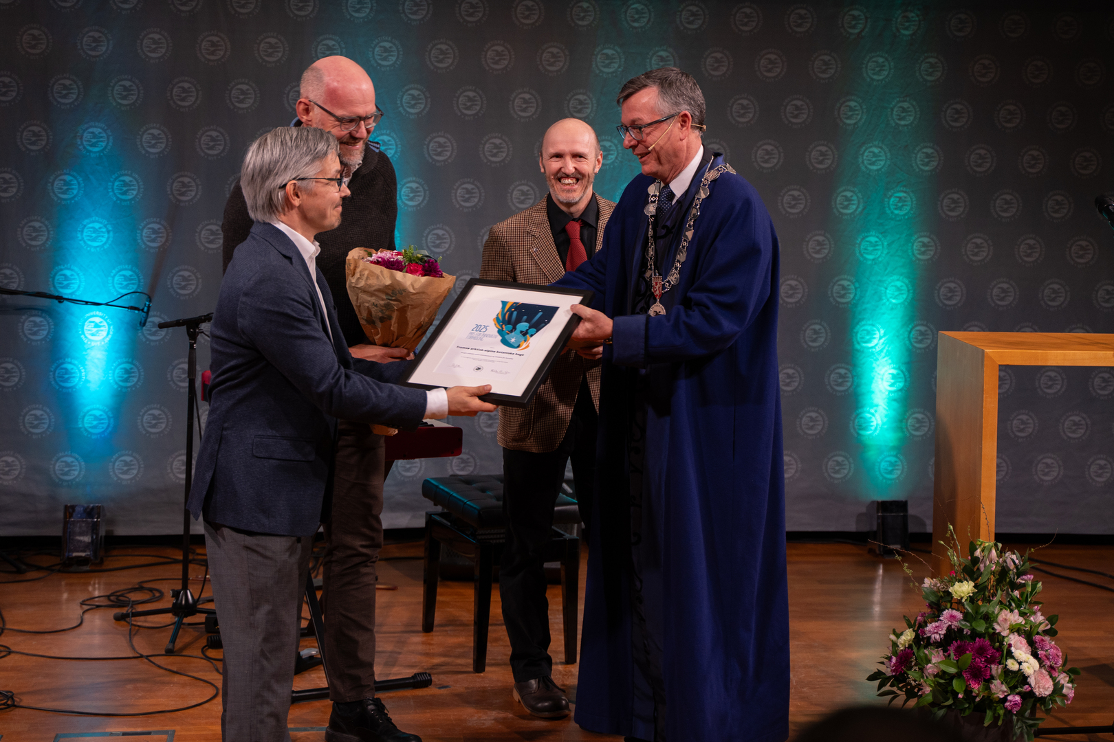Innovativ formidling-03672.jpg Tre mottar diplom, blomster og gave av universitetsrektor.