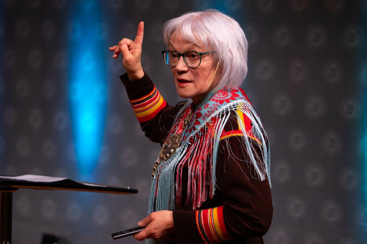 dame med samisk kofte som prater p&aring; en scene