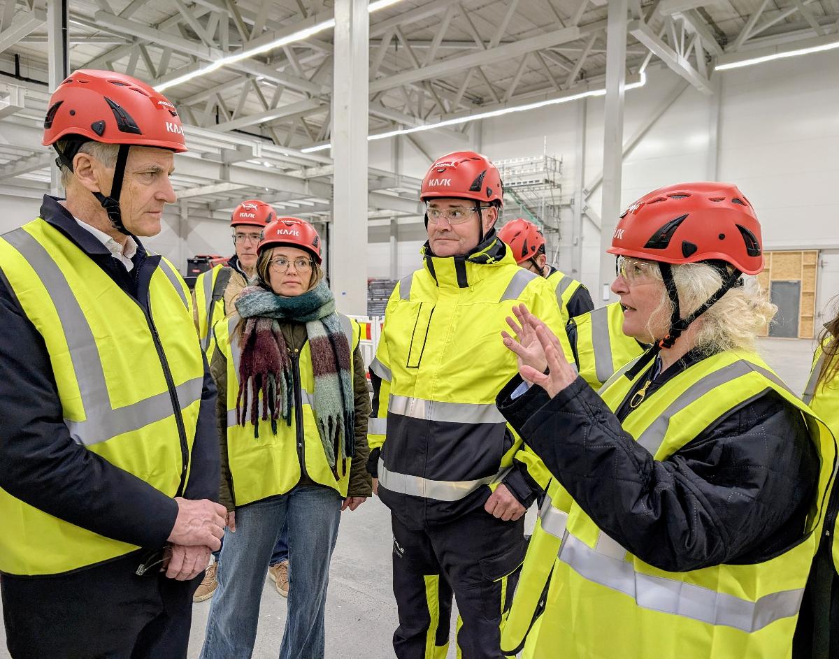 To personer snakker sammen i fabrikkhall. 