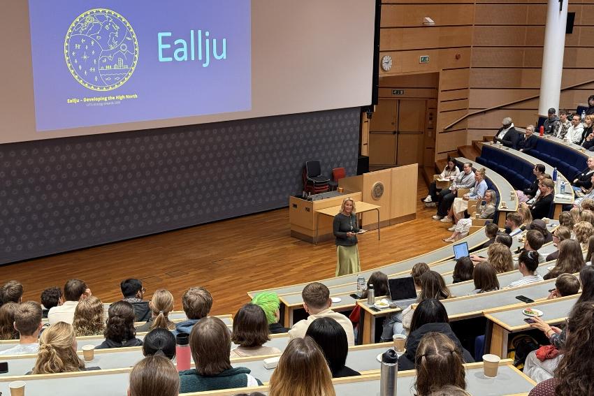 Studenter samlet i et audiotorium, mens de lytter til en taler.