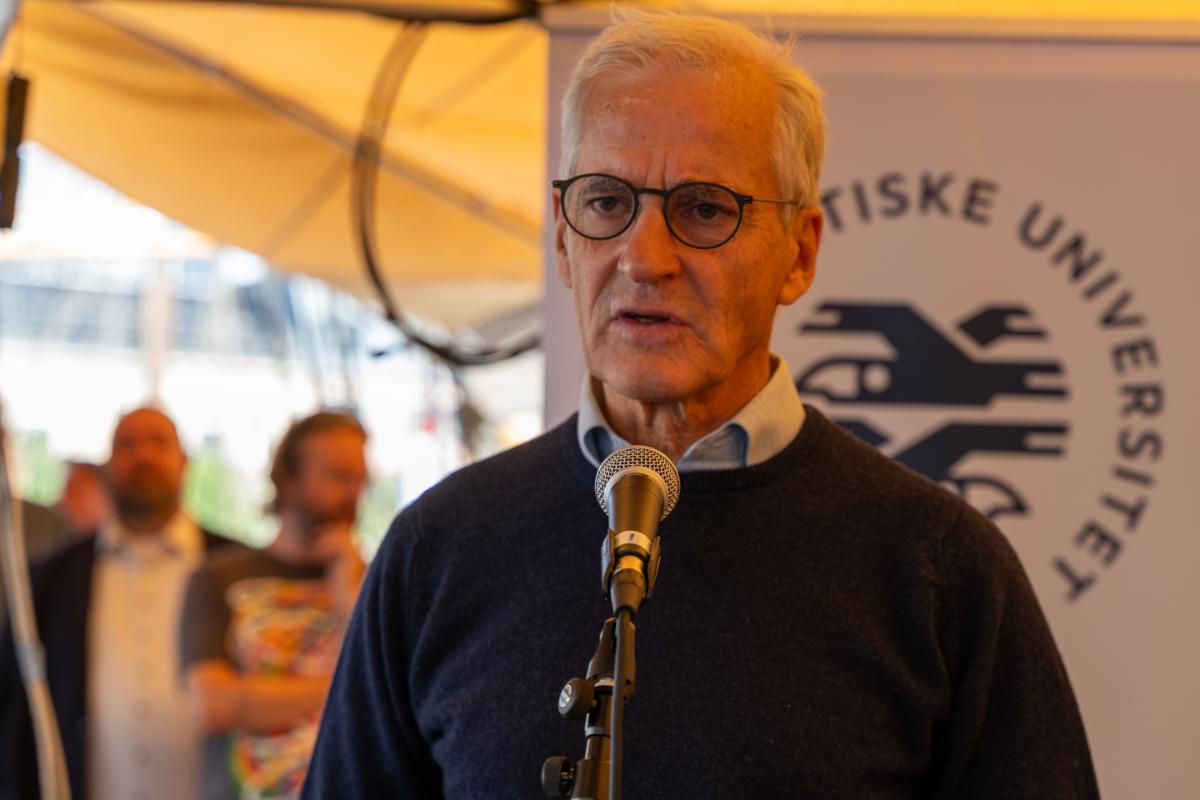 Statsminister Jonas Gahr St&oslash;re p&aring; Arendalsuka, med logoen til UiT Norges arktiske universitet i bakgrunnen