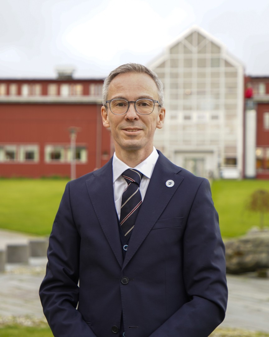 Portrettfoto av en mann foran et bygg.