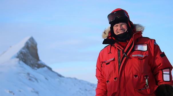 Foto av en person med r&oslash;d ytterjakke i sn&oslash;kledt landskap.